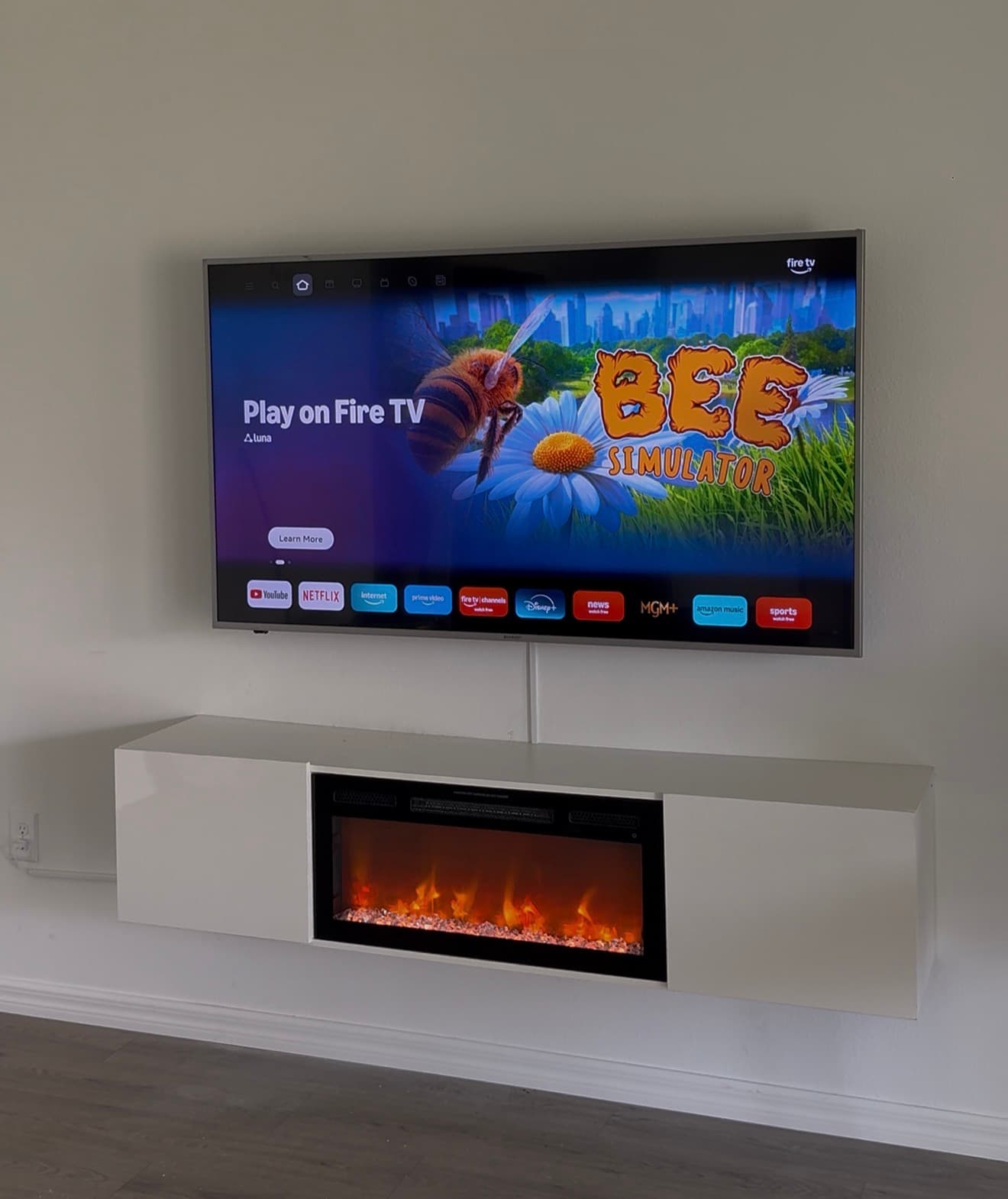 TV mounted above floating media console with electric fireplace, Tampa